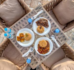 开罗Villa Khufu Pyramids Inn的一张桌子上放着三盘食物