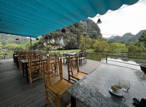 宁平HoangLong Riverside Homestay的河景甲板配有桌椅