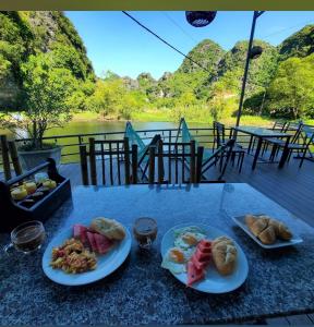 宁平HoangLong Riverside Homestay的上面有两盘食物的桌子