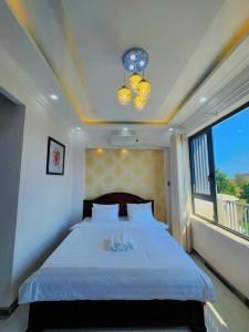 莲三Apec Sunsea Condotel Phu Yen的一间卧室设有一张大床和一个窗户。