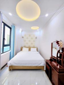莲三Apec Sunsea Condotel Phu Yen的白色卧室配有床和镜子