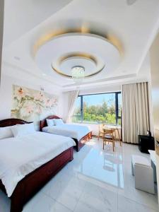 莲三Apec Sunsea Condotel Phu Yen的一间设有两张床和吊灯的大卧室