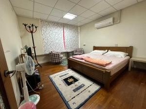 Fang-liao枋寮枋居背包客棧Fang Ju Backpackers的一间卧室,卧室内配有一张床和地毯
