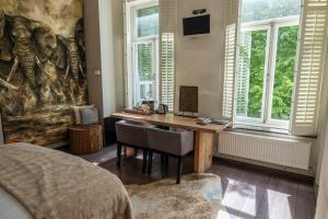 马斯特里赫特博提科酒店的一间带书桌的卧室,位于带窗户的房间内
