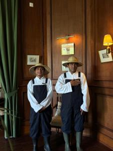 清迈Sela Chiangmai的穿着制服的两个人站在一间房间里