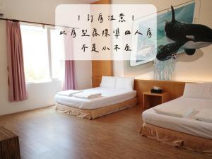小琉球岛小杉丘民宿的一间墙上写着书的带两张床的房间