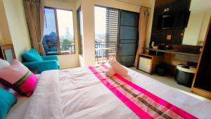 芭东海滩Lucky Buako Hotel Patong的一间卧室设有一张大床和大窗户