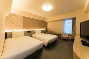 青森里士满青森酒店的酒店客房设有两张床和一台平面电视。