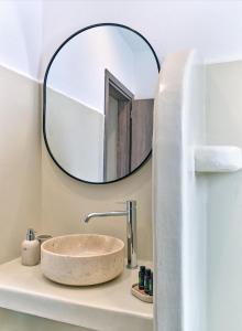 帕罗斯岛Paridian Elegant Living的浴室水槽和上面的圆镜子