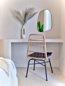 帕罗斯岛Paridian Elegant Living的卧室里一张藤椅和镜子