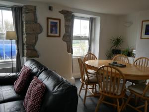 波特兰Fishermans Cottage的客厅配有桌子和真皮沙发