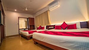 乌代浦Uddhav Vilas A Family Hotel的酒店客房 - 带两张带红色枕头的床