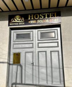 撒马尔罕MrShox Hostel的上面标有酒店标志的金属车库门