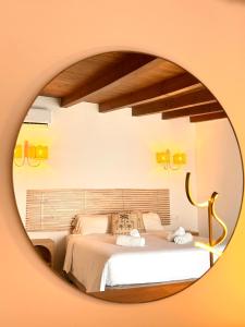 马贝拉Marbella Village的一间卧室配有一张带圆形镜子的大床