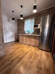 Višķi玛兹里格兹迪纳度假屋的厨房配有不锈钢冰箱和木地板