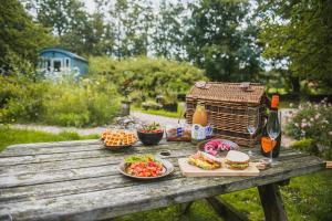 WaskemeerTiny Houses Bij De Compagnons的餐桌,餐桌上摆放着食物和饮料,鸟笼