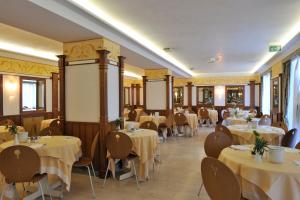利尼亚诺萨比亚多罗米拉马雷酒店的一间在房间内配有桌椅的餐厅