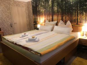 巴德斯特本Ban Thai Ferienwohnung Bad Steben的一张大床,上面有毛巾