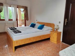 扎马迪NORA Guesthouse and Restaurant的一间卧室配有一张带蓝色枕头的大型木制床。