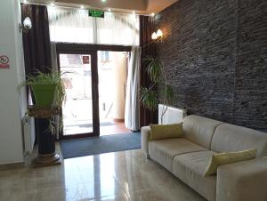 奥拉迪亚RHC皇家酒店的带沙发和砖墙的客厅