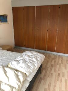纳克斯考Langø, ferielejlighed的一间卧室配有一张床和木制橱柜