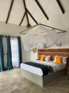 阿鲁沙Tanzania Safari Lodge的一间卧室配有一张挂在天花板上的蚊帐