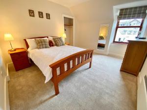 布雷马Bruachdryne Braemar Accommodation的一间卧室设有一张大床和一个窗户。