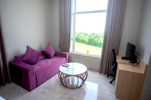 贾姆讷格尔Nulife Resort的客厅配有紫色沙发和窗户
