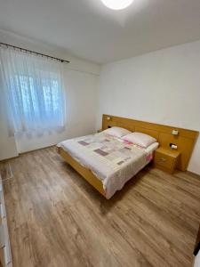 巴尔巴特纳拉布Apartmani Krunić的一间卧室配有一张床,铺有木地板
