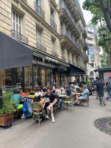 巴黎Paris 16 Victor Hugo superbe studio的一群坐在大楼外桌子上的人
