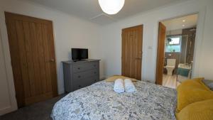 Saint BlazeyChy Lowen Private rooms with kitchen, dining room and garden access close to Eden Project & beaches的一间卧室,床上有两双白鞋