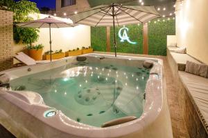 恩塞纳达港Casa Asturias的一个带遮阳伞的客房内按摩浴缸