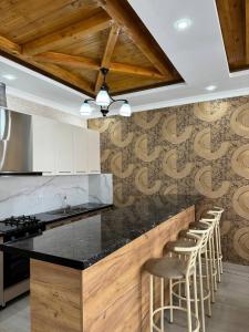 博孔巴耶沃Айкол的厨房配有吧台和酒吧凳