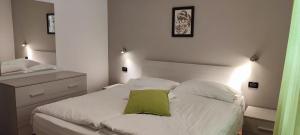 福尔加里亚Appartamento Alba的卧室配有白色床和绿色枕头