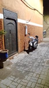 马拉喀什Riad Laila的停在有门的建筑物旁边的摩托车