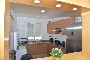 非斯Golf Royal appartement的厨房配有木制橱柜和不锈钢冰箱。