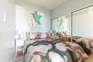 多伦多GLOBALSTAY Maple Leaf Square的一间卧室设有两张床,墙上挂有绘画作品