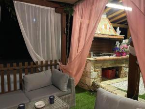 桑加拉达Marios guesthouse Pelion的带沙发和石头壁炉的庭院