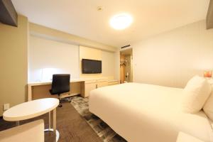 成田成田Richmond酒店的酒店客房设有一张床、一张书桌和一台电视机。