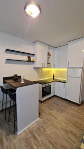 巴什卡沃达Apartments Mediteraneo的一间大厨房,配有白色的橱柜和一张桌子