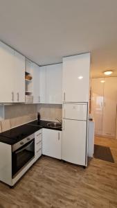 巴什卡沃达Apartments Mediteraneo的厨房配有白色橱柜和冰箱。