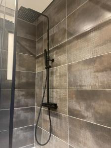巴涅尔-德吕雄Gîte pour 8 personnes proche des télécabines的浴室内带软管的淋浴