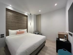 台中市侎雅行旅 台中捷運站館 Mya INN的卧室配有白色的床和木墙