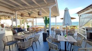 迈加洛丘里Hotel Beach Amaryllis的一间带桌椅和遮阳伞的餐厅
