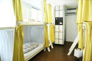 那霸亚洲小旅馆的客房设有两张双层床和黄色窗帘