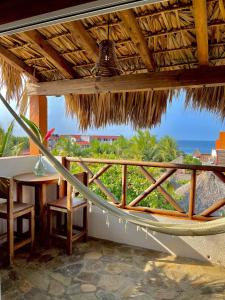 兹波利特Hotel Casa Mixteca的阳台配有桌子,享有海景。