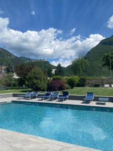 Calliano老鹰村酒店的一组蓝色的躺椅和一个游泳池