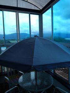 比亚维森西奥Hotel Najjez的坐在一张桌子上的一把黑伞