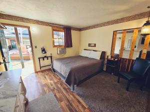 戴德伍德Cedar Wood Inn的一间卧室配有一张床、一张桌子和一把椅子