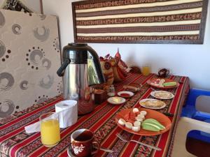 普诺Q'OTA TAYPY LODGE的餐桌,带咖啡壶和盘子的食物